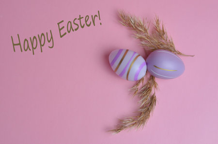 Colorful Easter eggs on a pink background. Happy Easter text