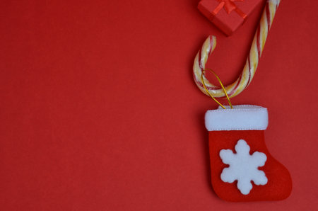 Christmas sock and candy cane. Red background.