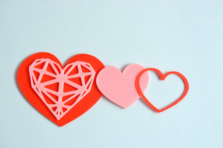 Red and pink heart decorations on a blue background. February 14.