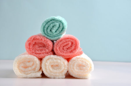 Multi-colored towels are placed in a slide on a blue background.の写真素材