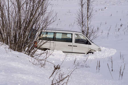 Car in ditch after winter accident. Vehicle loses control and drove off road at ice.の写真素材