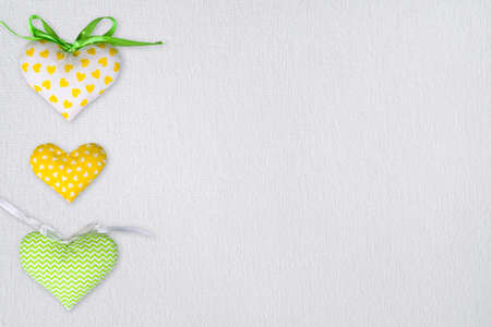 Set textile fabric toy heart on white canvas background. St. Valentine's Day postcard template with copy spaceの写真素材