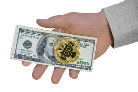 Golden bitcoin and hundred dollar bills in hand. Giving american money cash, isolated on whiteの写真素材