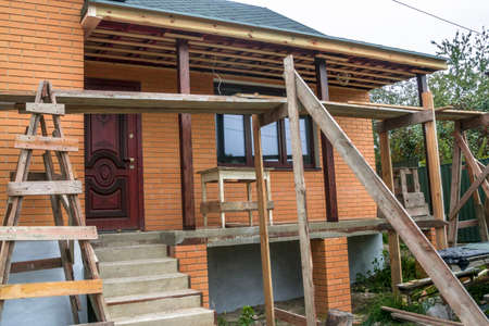 Building brick house outside the city. Foreground with scaffolding