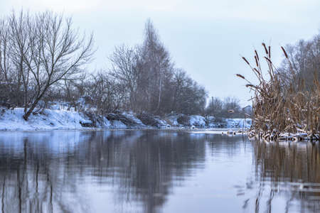 Winter landscape of frosty snowy river with shores covered snowの写真素材