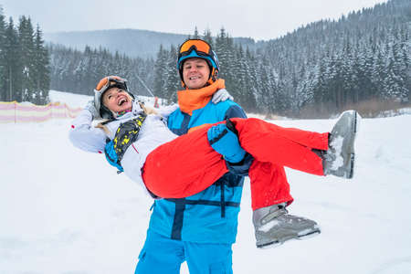 Happy couple people have fun and enjoy the fresh snow in winter mountains Carpathians.の写真素材