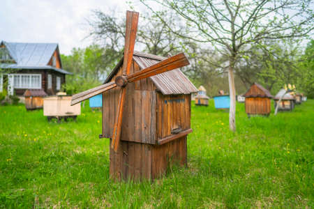Decorative wooden beehives at apiary. Bee hive in village green garden.