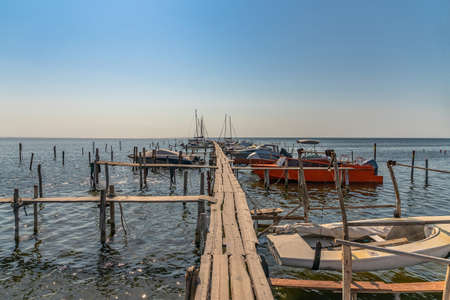Old wood boats pier. Little wooden platform for boat and speedboat at sea marinaの写真素材