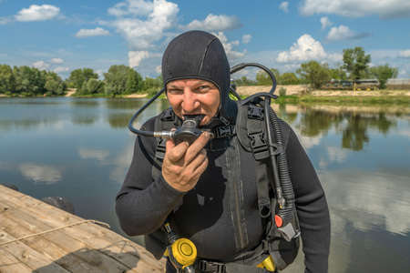 Smiling scuba diver with equipment ready for diving