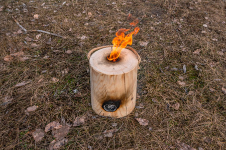 Vertical fire of Finnish (Swedish) log candle at river coastの写真素材