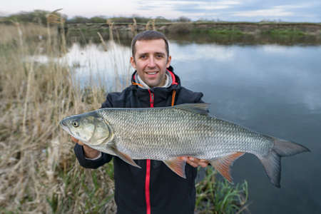 Asp fishing. Happy fisherman with big aspius fishの写真素材