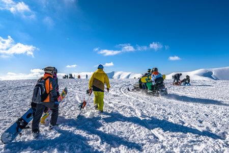 Ukraine, Pylypets - February 20, 2021. Snowboarders and skiers at snowy mountains. People in...