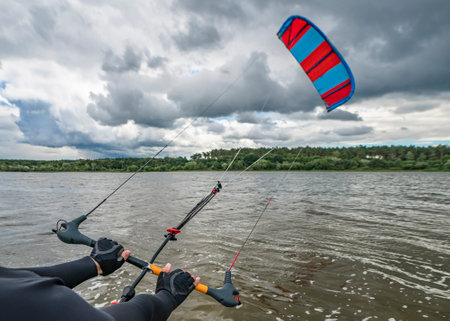 Hands of kitesurfer hold kitesurfing bar with run kite in airの写真素材