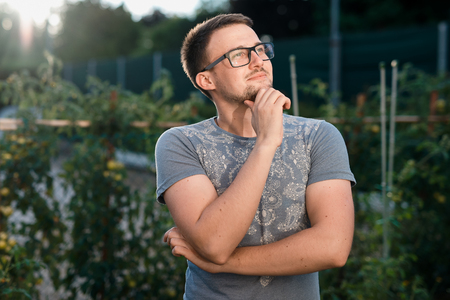 pensive happy boy eyeglasses at sunset in parkの写真素材