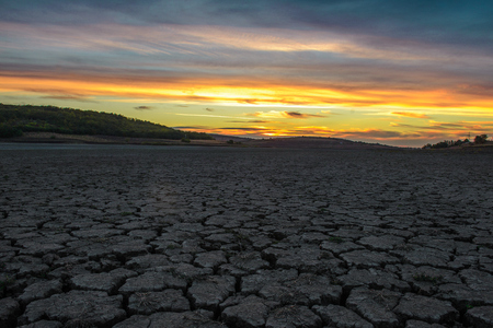 Dry mud, after the pond is dried, on the sunset background.の写真素材