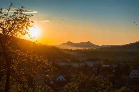 Beautiful landscape of sunrise over small town in forest mountains. Romania, Sighisoara - 2016.の写真素材