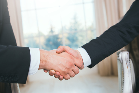 Handshake of two people, businessmen on a light background.の写真素材