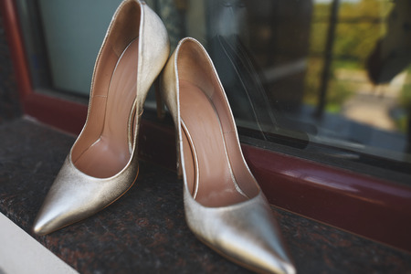 Stylish bride wedding shoes on window background.の写真素材