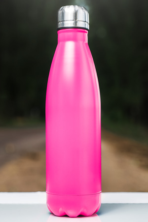 Stainless  water bottle on white table, outdoor. Pink colorの写真素材