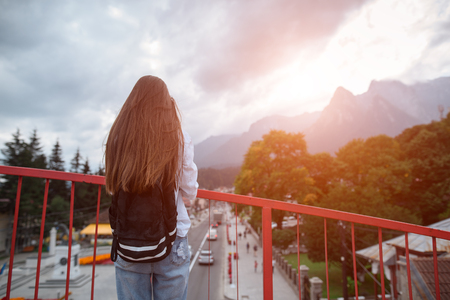 Back View of teenager with backpack on background of mountains and cityの写真素材