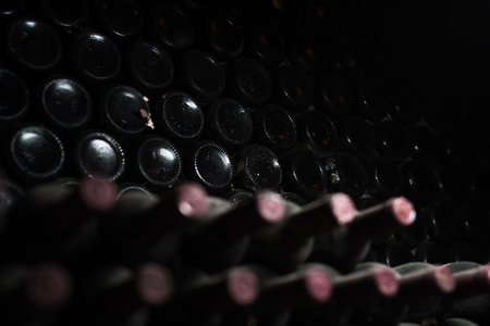 Old red wine bottles in dark cellarの写真素材