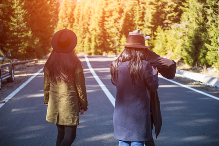 Back view of hipsters on road in forestの写真素材