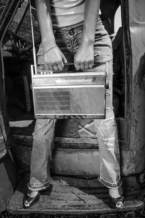 Retro girl with vintage radio in hands. Black and whiteの写真素材
