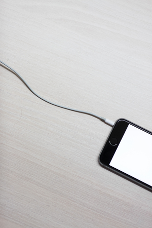 Smartphone with mockup screen and cable from chargingの写真素材