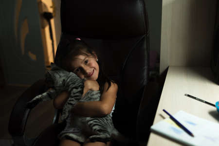 Cute little kid girl hug shes cat at homeの写真素材
