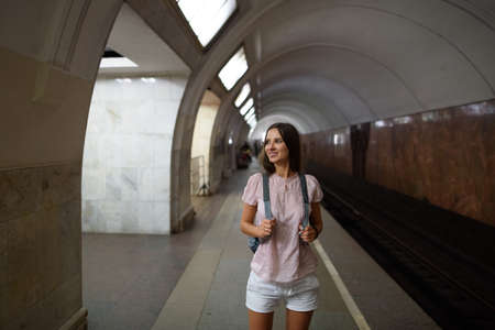 Young hipster girl with backpack in metroの写真素材