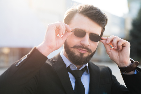 Portrait of bearded hipster with sunglasses dressed in suit.の写真素材
