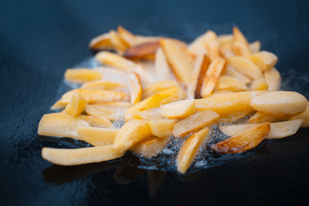 Close-up of cooking potatoes in flat pan on bonfire.の写真素材