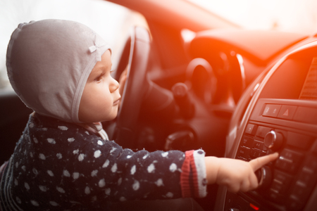 Baby girl use audio system of modern car.の写真素材