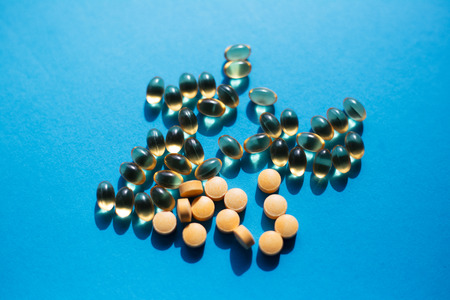 Vitamine medicine pills on the blue background.