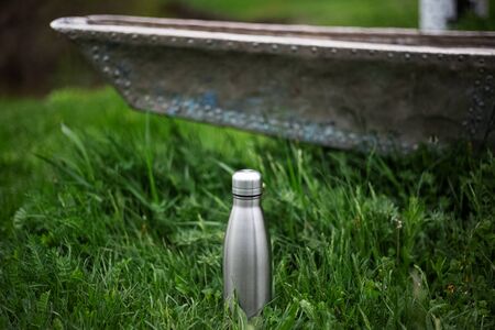Stainless thermo bottle in green grassの写真素材