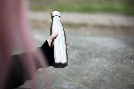 Stainless thermal bottle for water in hand.