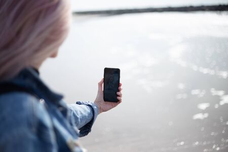 Close up of young girl taking selfie on the beach.
