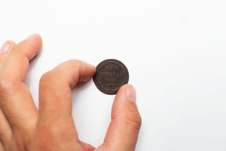 Hand take ancient coin of 1865 from white background.
