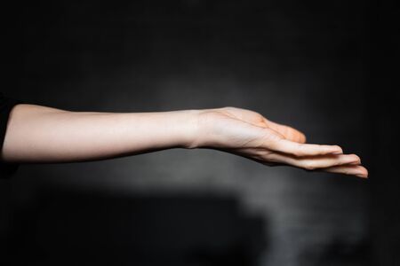 Female hand on black background.の写真素材