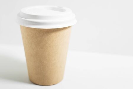 Close-up of disposable paper cup for coffee take away, with white lid, isolated on white background.の写真素材