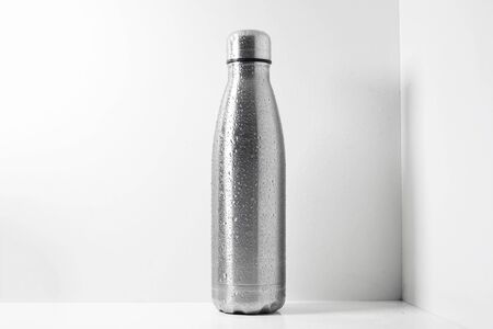 Steel thermo bottle sprayed with water on white background.の写真素材