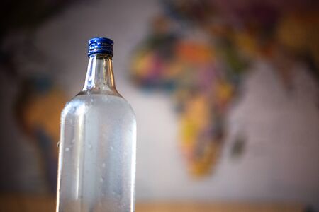 Close-up of glass bottle with water on blurred background.の写真素材