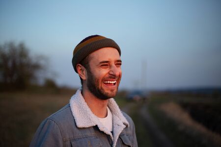 Portrait of smiling young hipster in denim jacket and cap.の写真素材