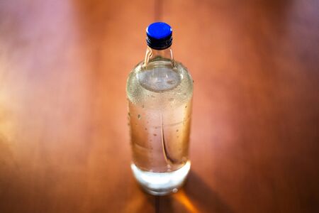 Close-up of glass bottle with water on blurred background.の写真素材