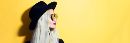 Panoramic profile portrait of young teenage blonde girl wearing sunglasses and black hat on...