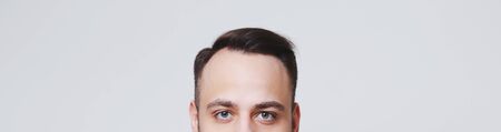 Close-up of male forehead on background of panoramic banner background of white.