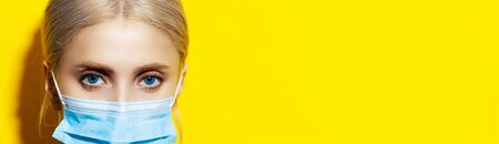 Close-up portrait of young doctor wearing medical face mask against coronavirus. Studio background...