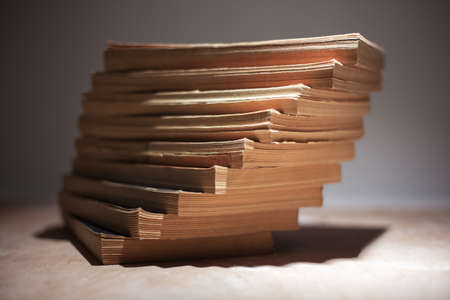 Close-up of stack of books on wooden table.