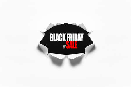 Black Friday sale text in torn hole in the sheet of white paper.の写真素材