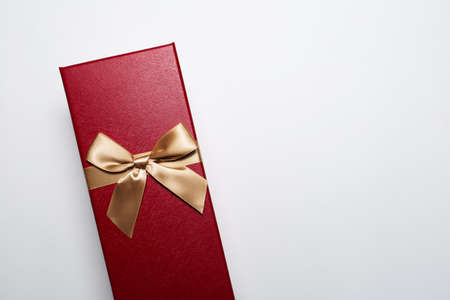 Close-up of Christmas gift box of red color with golden bow, isolated on white background with copy...